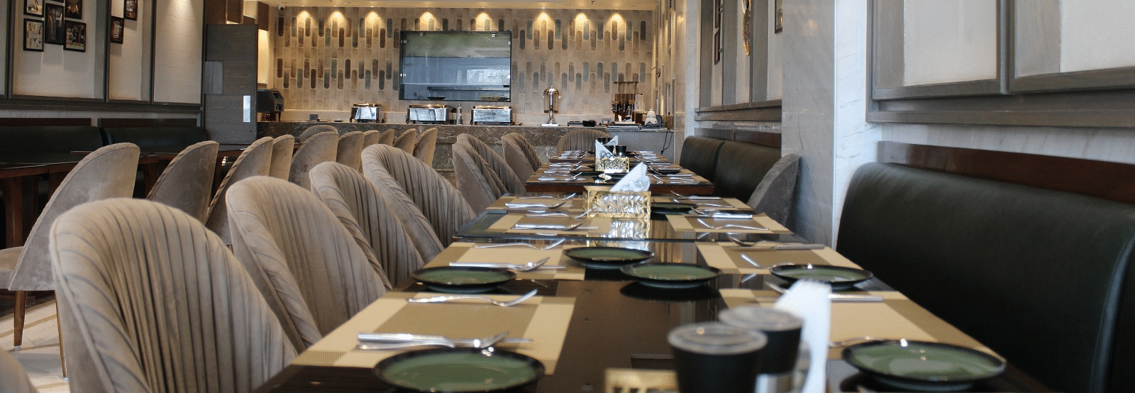 A well-arranged dining space featuring tables with chairs and neatly set cutlery at  BluSalzz Residence, Amritsar